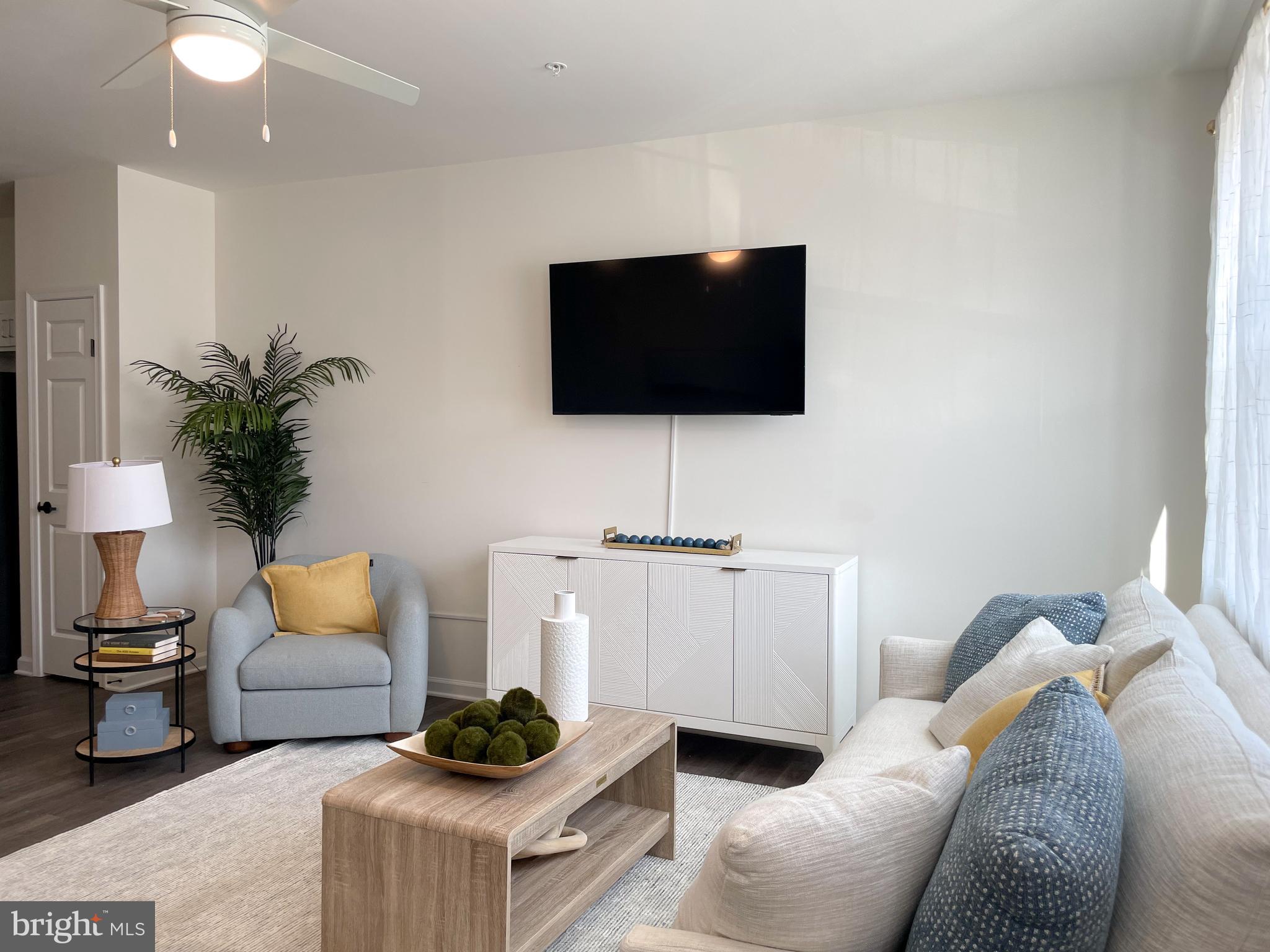 2105 Emden Lane, Unit 310 Lewes, DE 19958 - Photo 4 of 9 a living room with furniture and a flat screen tv