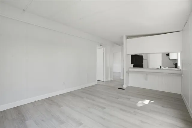 a view of an empty room and window with wooden floor
