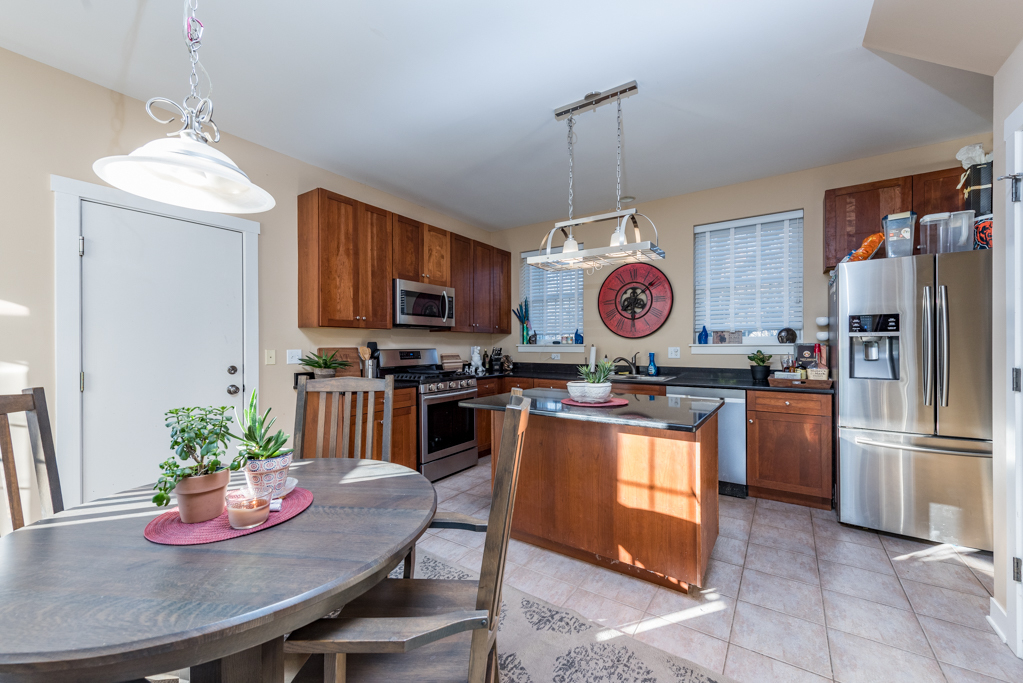 1004 Harris Road Grayslake, IL 60030 - Photo 6 of 24 a kitchen with stainless steel appliances granite countertop a refrigerator a stove a sink dishwasher a dining table and chairs with wooden floor