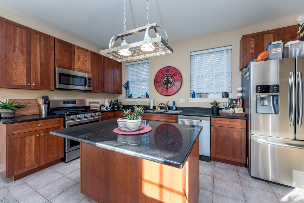 1004 Harris Road Grayslake, IL 60030 - Photo 7 of 24 a kitchen with granite countertop stainless steel appliances a stove top oven a refrigerator and a microwave