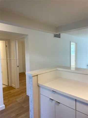 a room with a sink and wooden floor