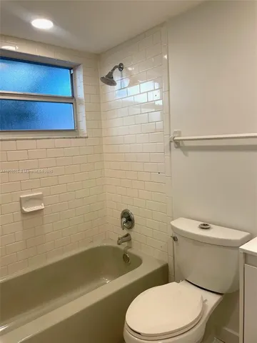 a white toilet and tub sitting next to a bathroom sink