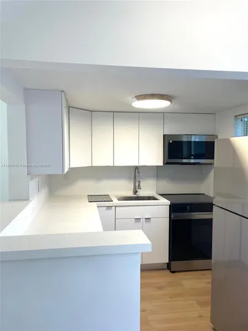 a kitchen with stainless steel appliances a sink stove and refrigerator