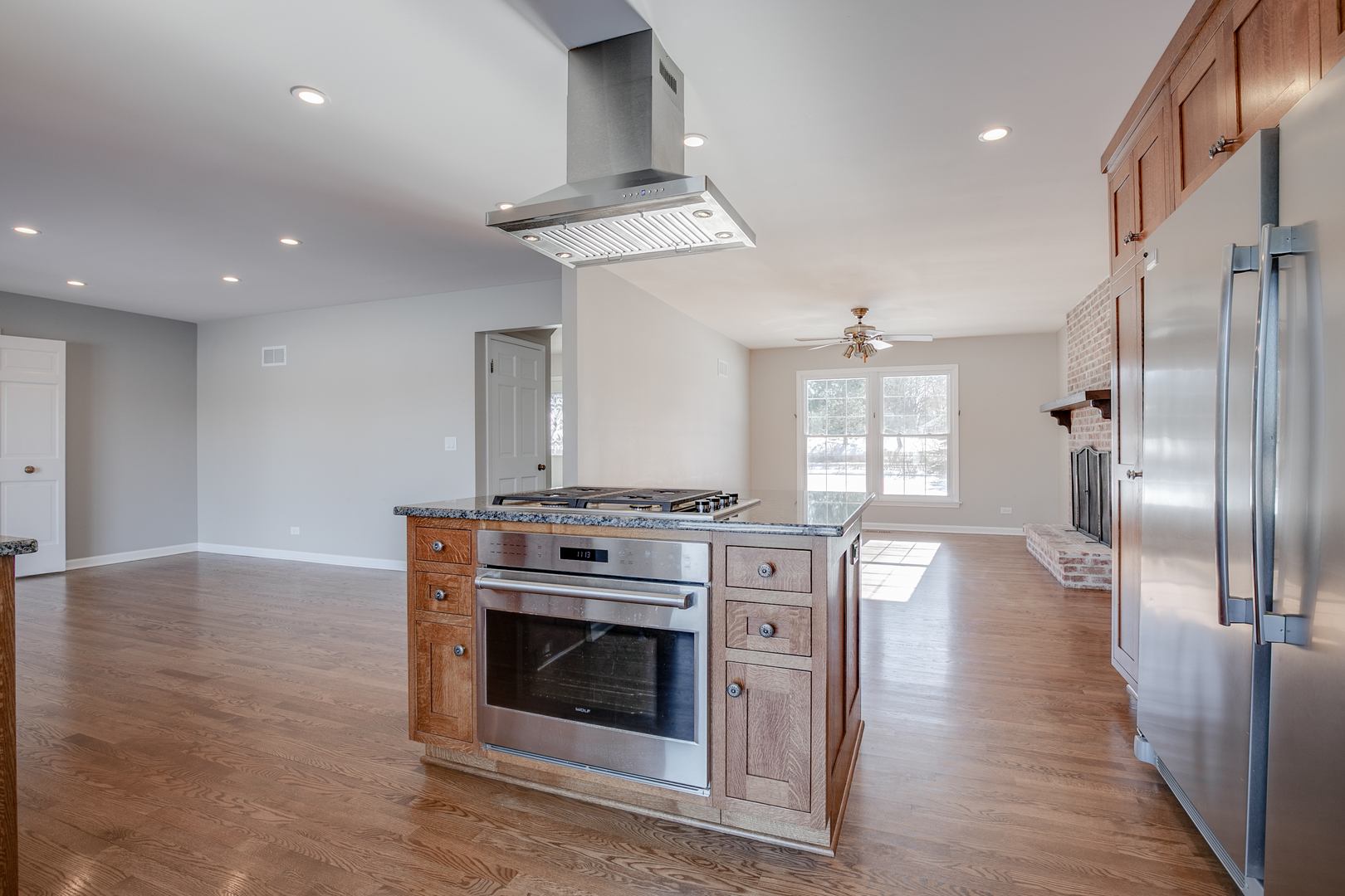 21242 West Long Grove Road Kildeer, IL 60047 - Photo 13 of 42 a kitchen with stainless steel appliances granite countertop a stove a refrigerator and a fireplace