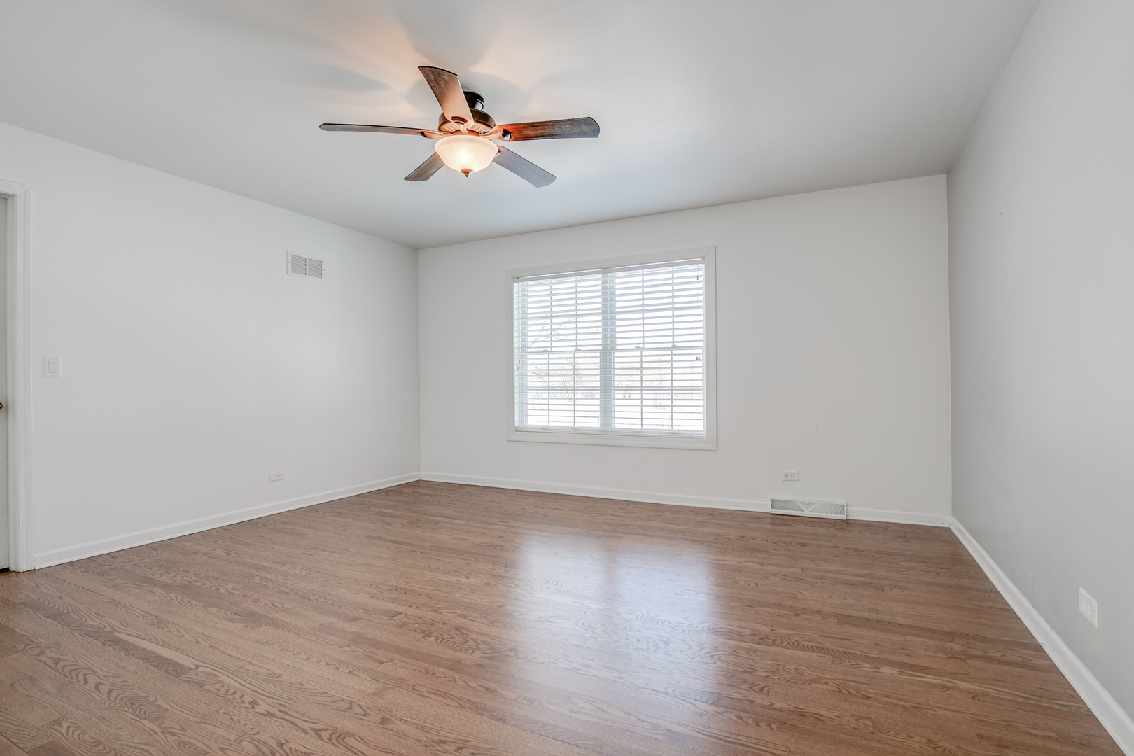 21242 West Long Grove Road Kildeer, IL 60047 - Photo 26 of 42 an empty room with wooden floor fan and windows