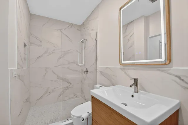 a bathroom with a sink a toilet and shower