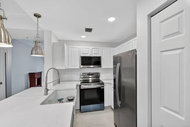 a kitchen with stainless steel appliances a refrigerator sink and stove