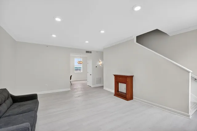 a view of an empty room with a window and a cabinet