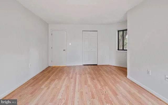 a view of an empty room with wooden floor