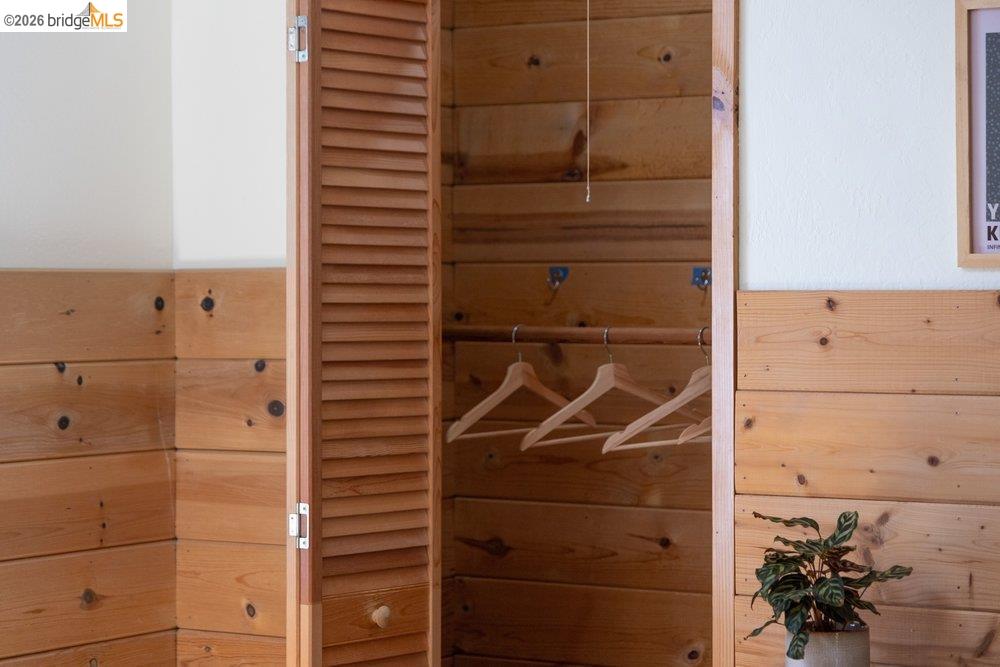 287 Purdue Avenue Kensington, CA 94708 - Photo 45 of 60 Built-in closet featuring louvered bi-fold doors, natural wood paneling, and a wood hanging rod