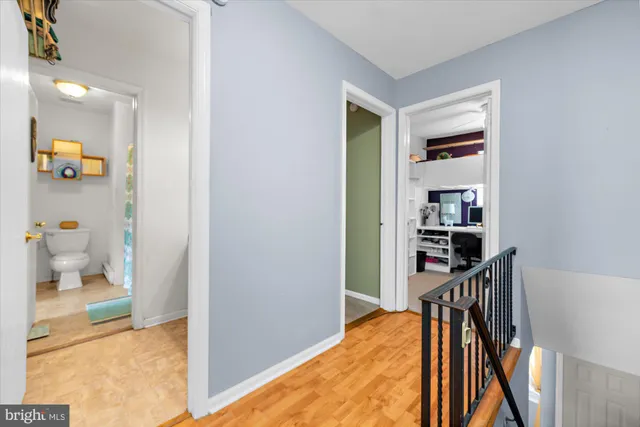 a view of a hallway with wooden floor and a living room