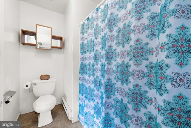 a bathroom with a toilet and a shower curtain