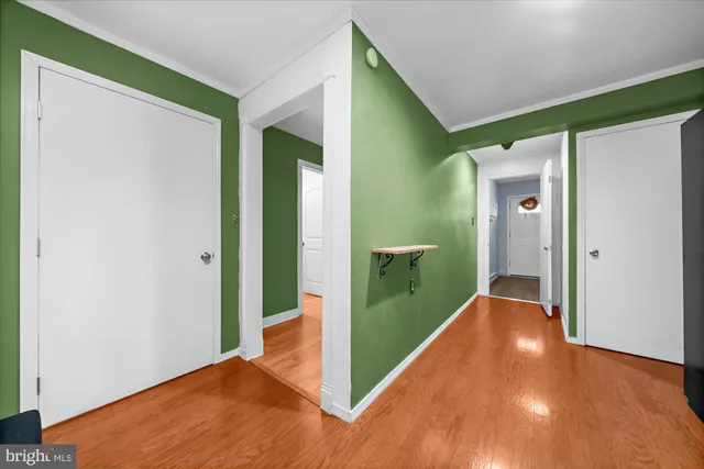 a view of hallway with bathroom and wooden floor