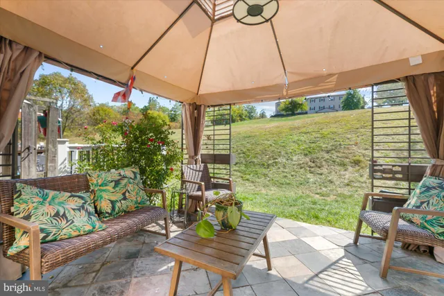a view of a patio with a table and chairs under an umbrella