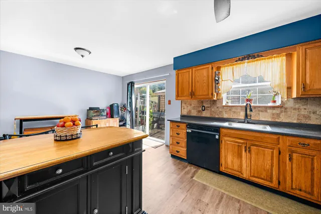 a kitchen with a sink a counter top space and stainless steel appliances