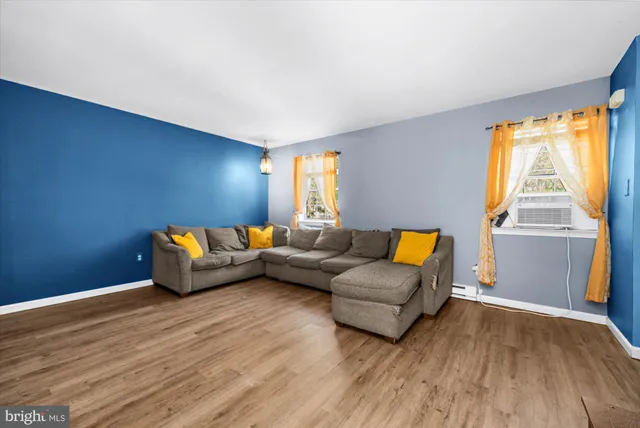 a living room with furniture and a wooden floor