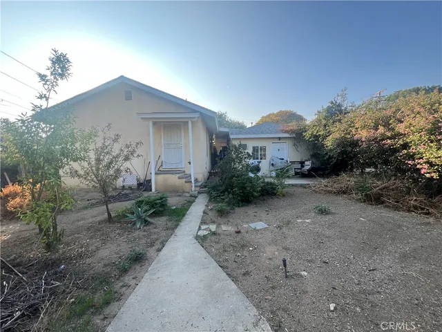 a view of a house with a yard and large tree