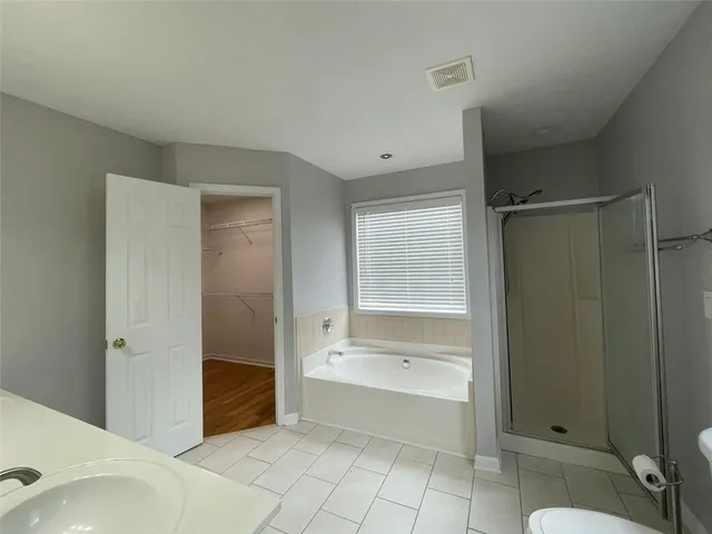 a spacious bathroom with a tub shower and sink