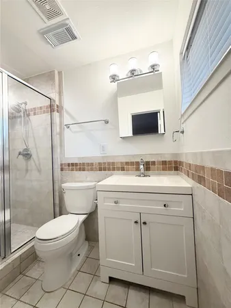 a bathroom with a granite countertop sink toilet and shower