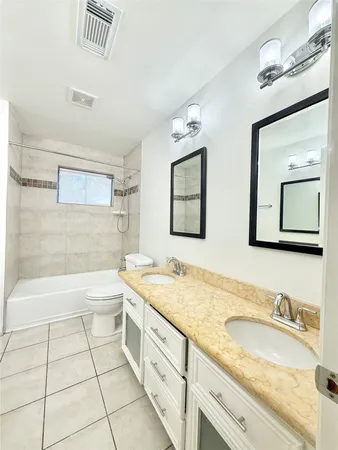 a bathroom with a granite countertop sink mirror and bathtub