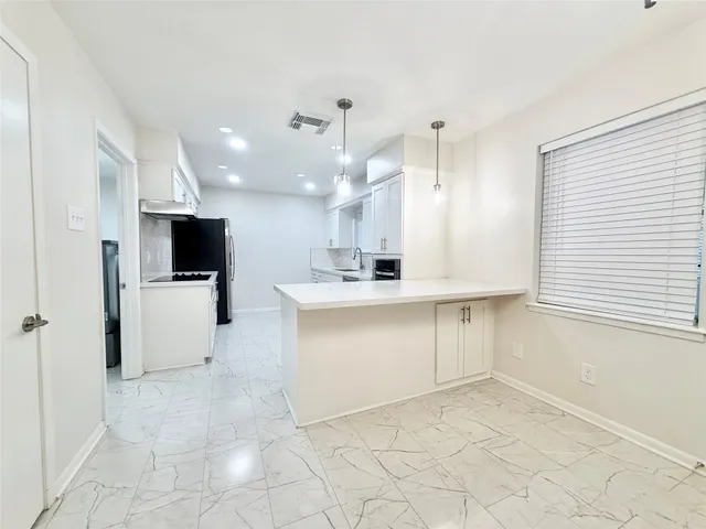 a view of a kitchen with a sink and a refrigerator