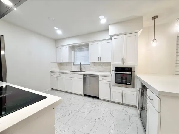 a kitchen with a sink a stove a microwave and cabinets