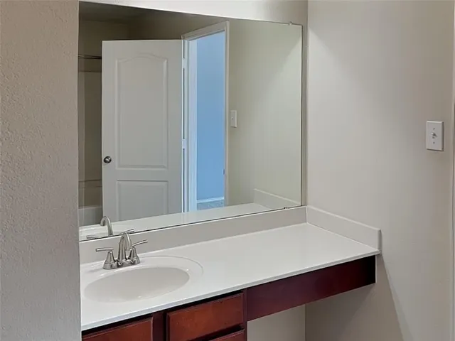 a bathroom with a sink vanity and a mirror