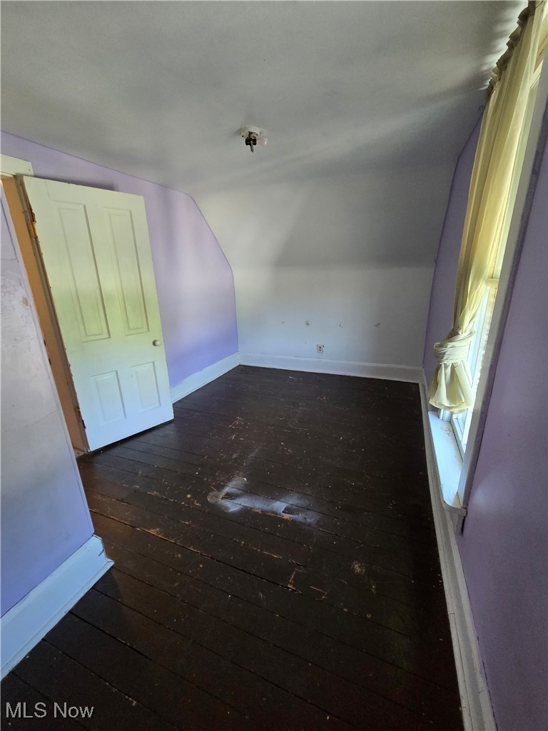 5555 Detroit Road Sheffield, OH 44054 - Photo 15 of 50 Empty room featuring lofted ceiling and dark wood-style floors