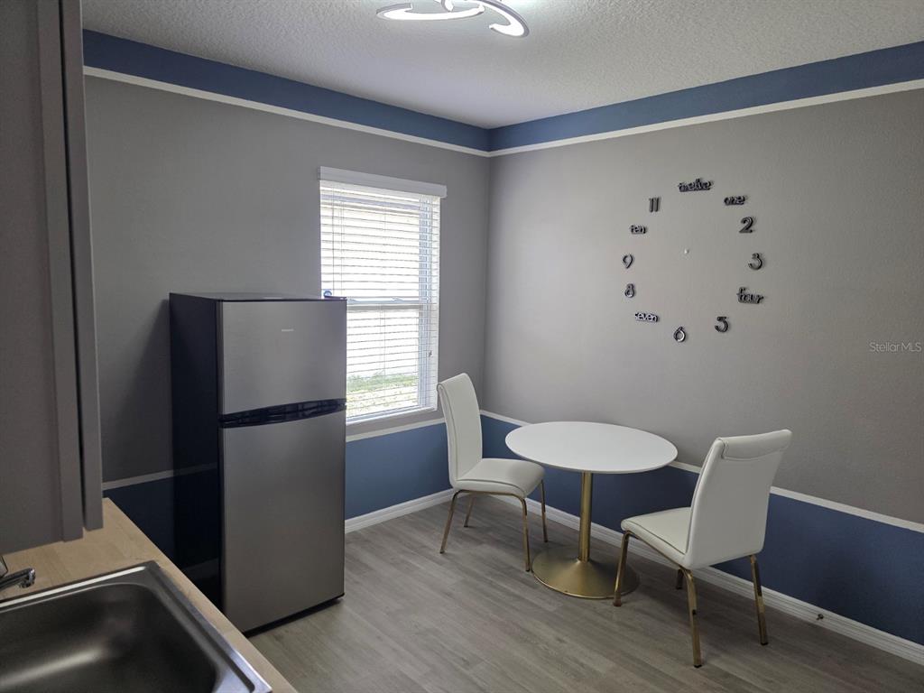 981 Chanler Drive Haines City, FL 33844 - Photo 4 of 11 a view of a room with furniture a refrigerator and wooden floor