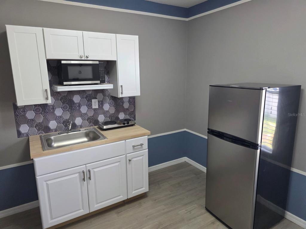 981 Chanler Drive Haines City, FL 33844 - Photo 8 of 11 a kitchen with stainless steel appliances granite countertop a refrigerator and a stove top oven