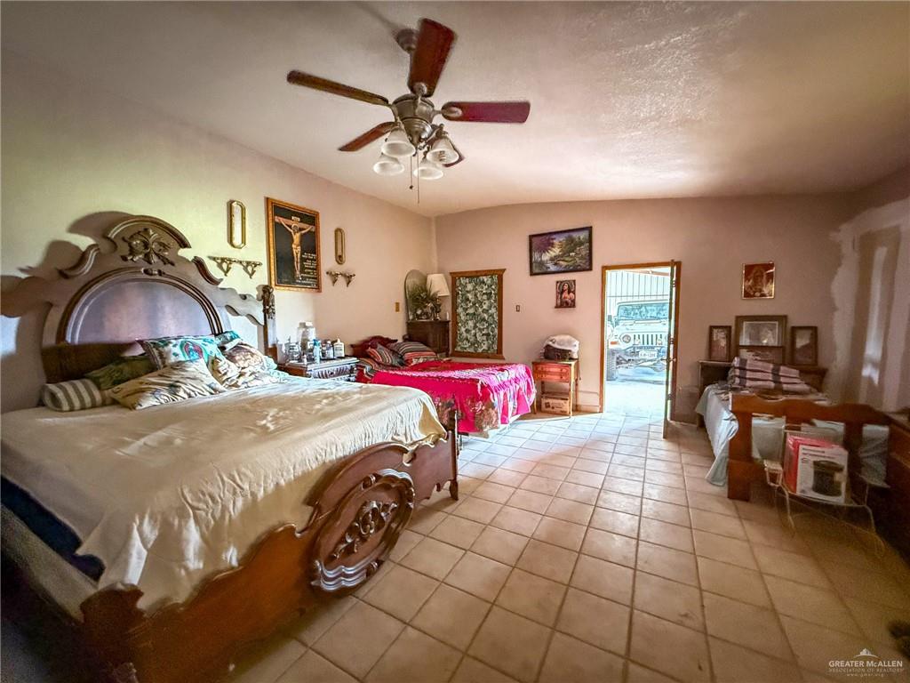 9 San Julian Road Roma, TX 78584 - Photo 12 of 28 a bedroom with a bed and a chandelier