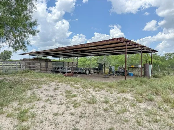 a view of a patio with table and chairs under an umbrella