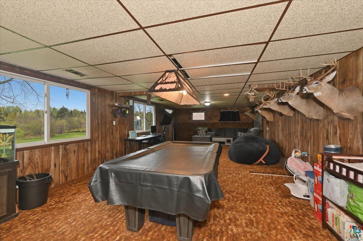 5190 County Road M Gordon, WI 54838 - Photo 16 of 31 Recreation room featuring wood paneling, drop ceiling, and a pool table under a rustic-style light fixture