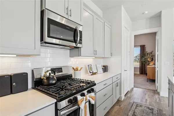 a kitchen with a sink white cabinets and white appliances