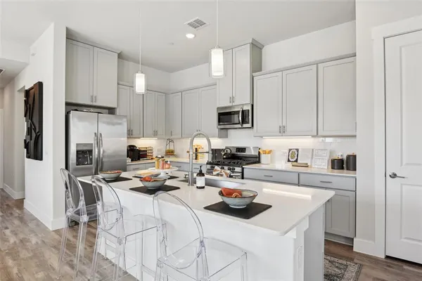 a kitchen with refrigerator a stove a sink dishwasher and a refrigerator with wooden floor