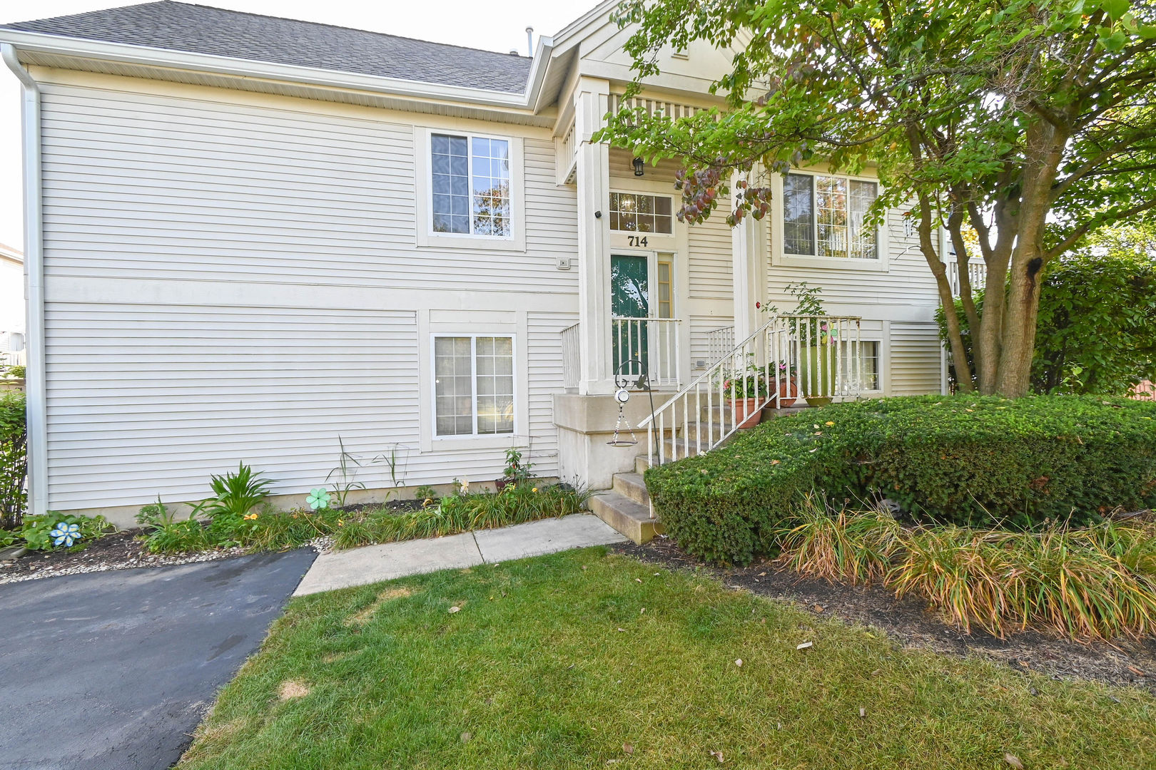 a front view of a house with a garden and plants