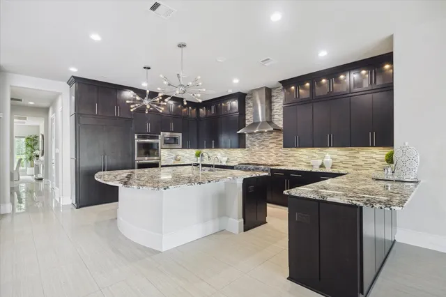 a kitchen with kitchen island a counter top space a sink cabinets and stainless steel appliances