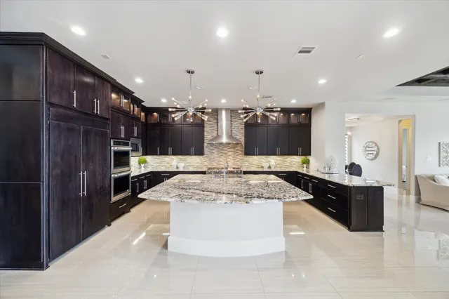 a large kitchen with stainless steel appliances kitchen island granite countertop a large counter top and stove