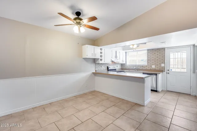 a kitchen with stainless steel appliances granite countertop a refrigerator a sink and a stove