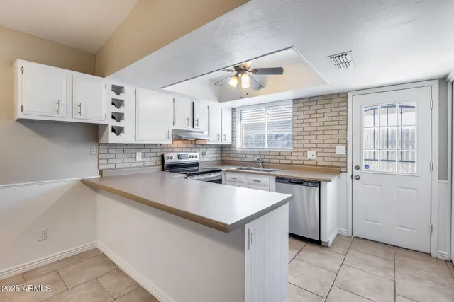a kitchen with cabinets stainless steel appliances and a chandelier