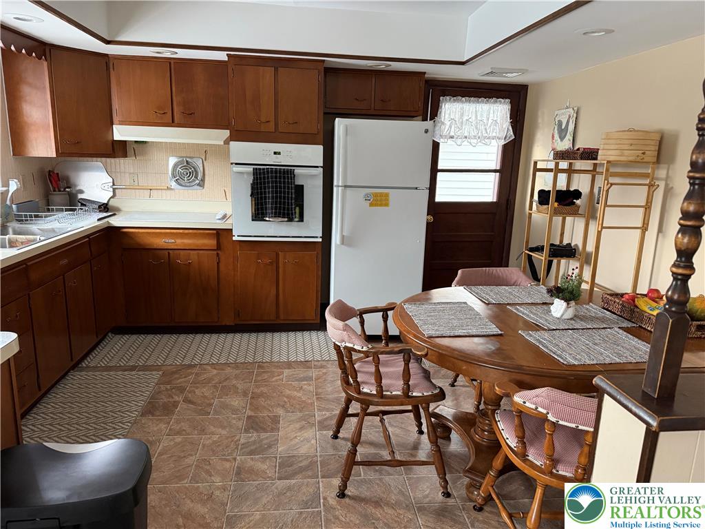 1445 Church Road Wind Gap, PA 18091 - Photo 16 of 37 a kitchen with stainless steel appliances a refrigerator a stove a sink a dining table and chairs