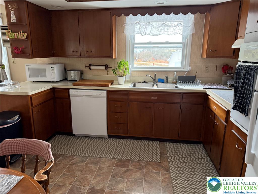 1445 Church Road Wind Gap, PA 18091 - Photo 18 of 37 a kitchen with stainless steel appliances granite countertop a sink stove refrigerator and cabinets