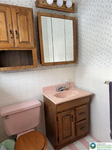 a bathroom with a sink a toilet and mirror