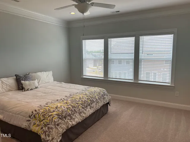 a large bed sitting in a bedroom next to a window