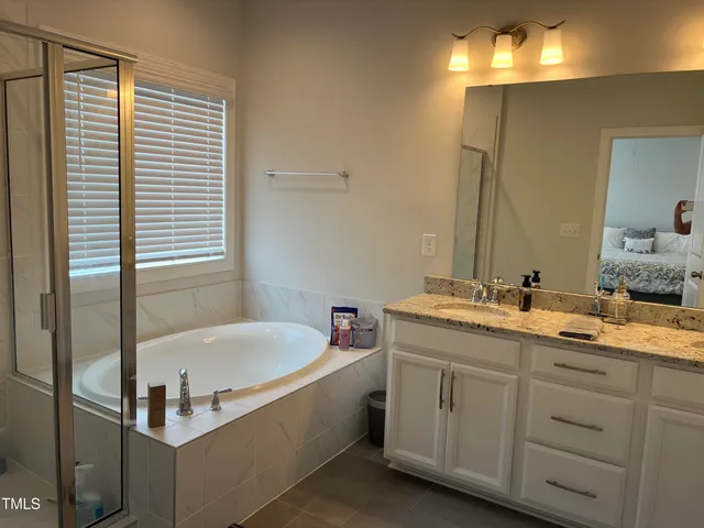 a bathroom with a tub sink and mirror