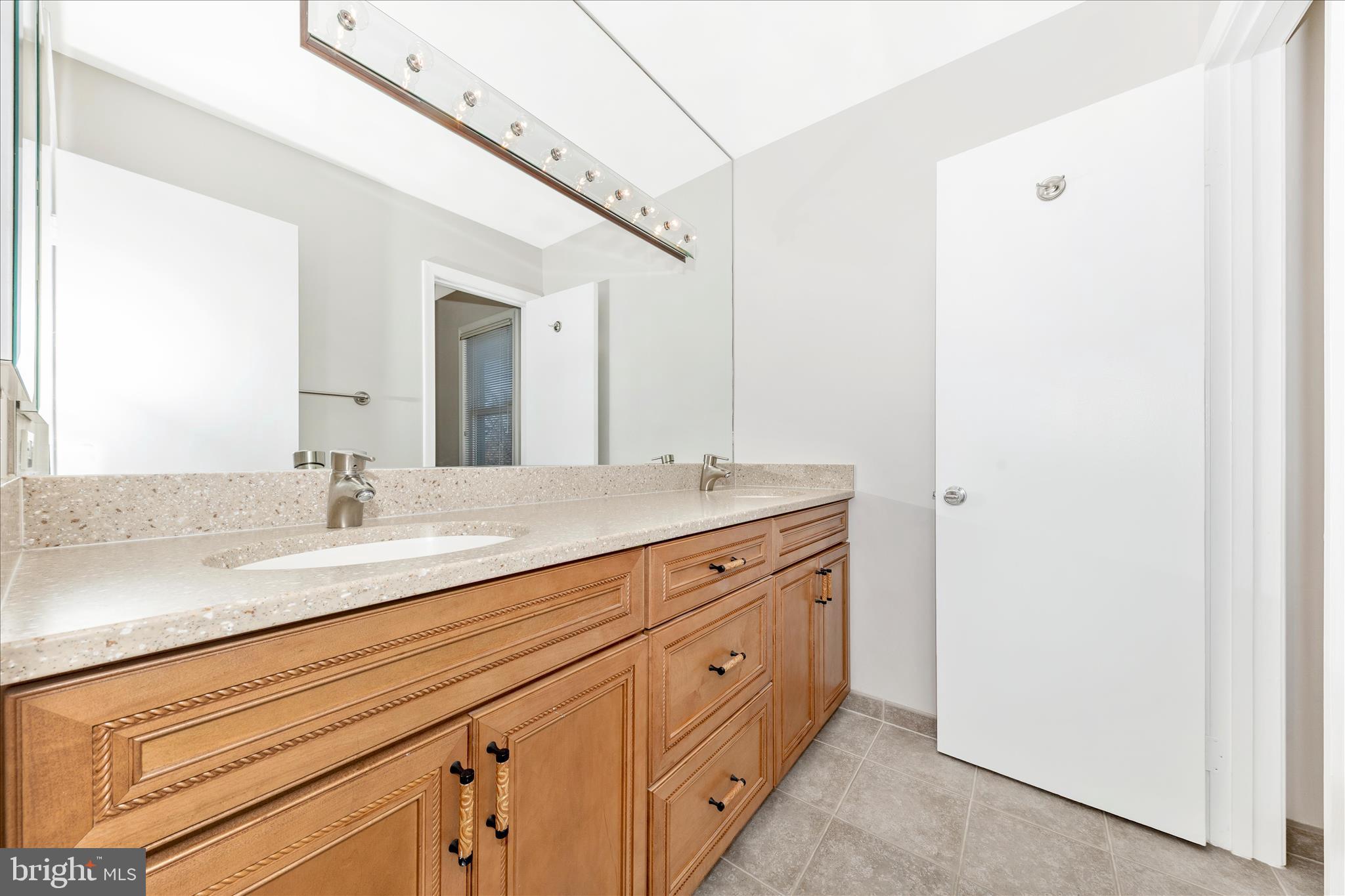 11806 Prestwick Road Potomac, MD 20854 - Photo 34 of 64 a bathroom with a double vanity sink and a mirror