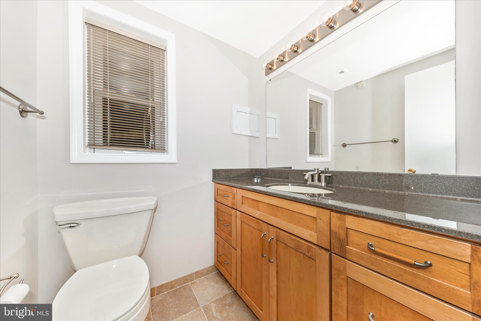 11806 Prestwick Road Potomac, MD 20854 - Photo 50 of 64 a bathroom with a toilet a sink and mirror