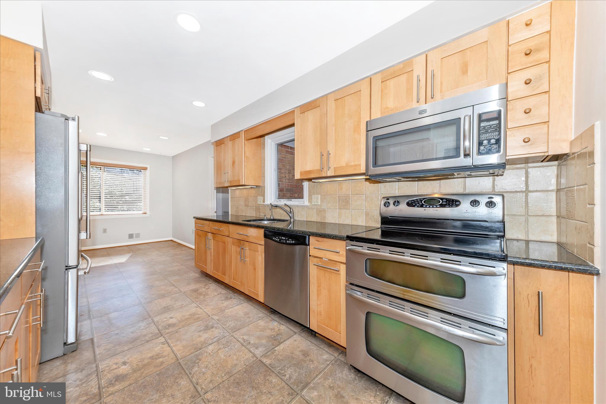 11806 Prestwick Road Potomac, MD 20854 - Photo 5 of 64 a kitchen with stainless steel appliances granite countertop a stove a sink and a microwave