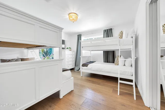 a bedroom with a bed and a flat tv screen on dresser