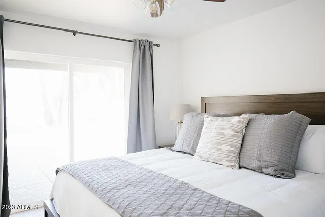 a bedroom with a bed and a large window